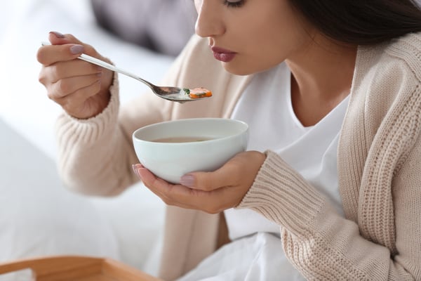 Sick woman eating soup