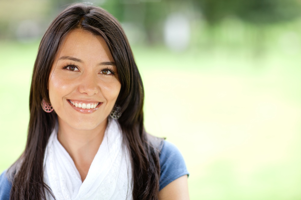 Portrait of a beautiful young woman smiling outdoors
