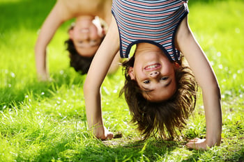 Portraits of happy kids playing upside down outdoors in summer park-1