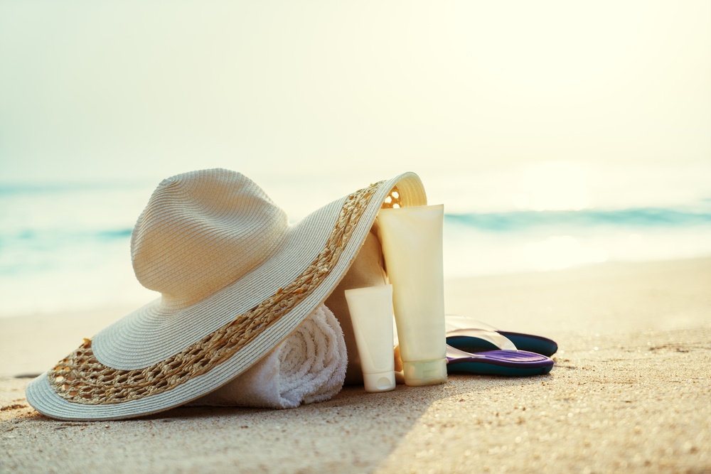 Sun lotion, hat  with bag at the beach