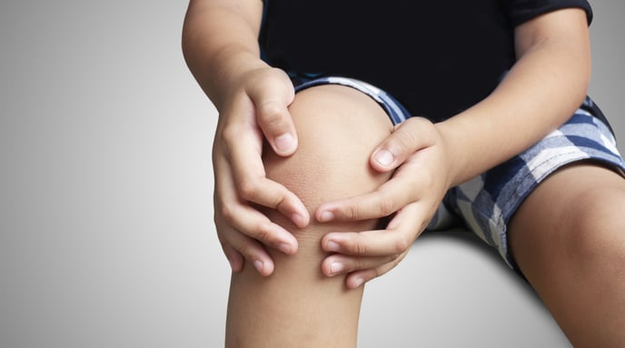Young boy holding knee in pain-1