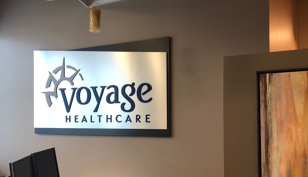 Voyage Healthcare logo in corporate lobby office