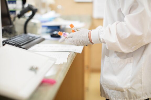 A healthcare provider handles multiple blood sample vials, preparing them for lab analysis to support accurate diagnosis and treatment planning.