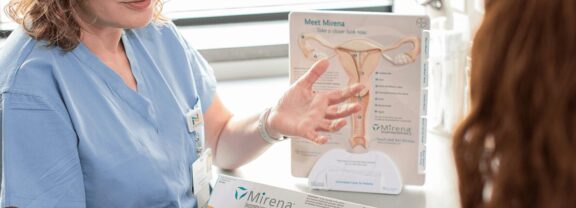 A healthcare professional discusses the Mirena intrauterine device with a patient, providing information on its benefits and usage.