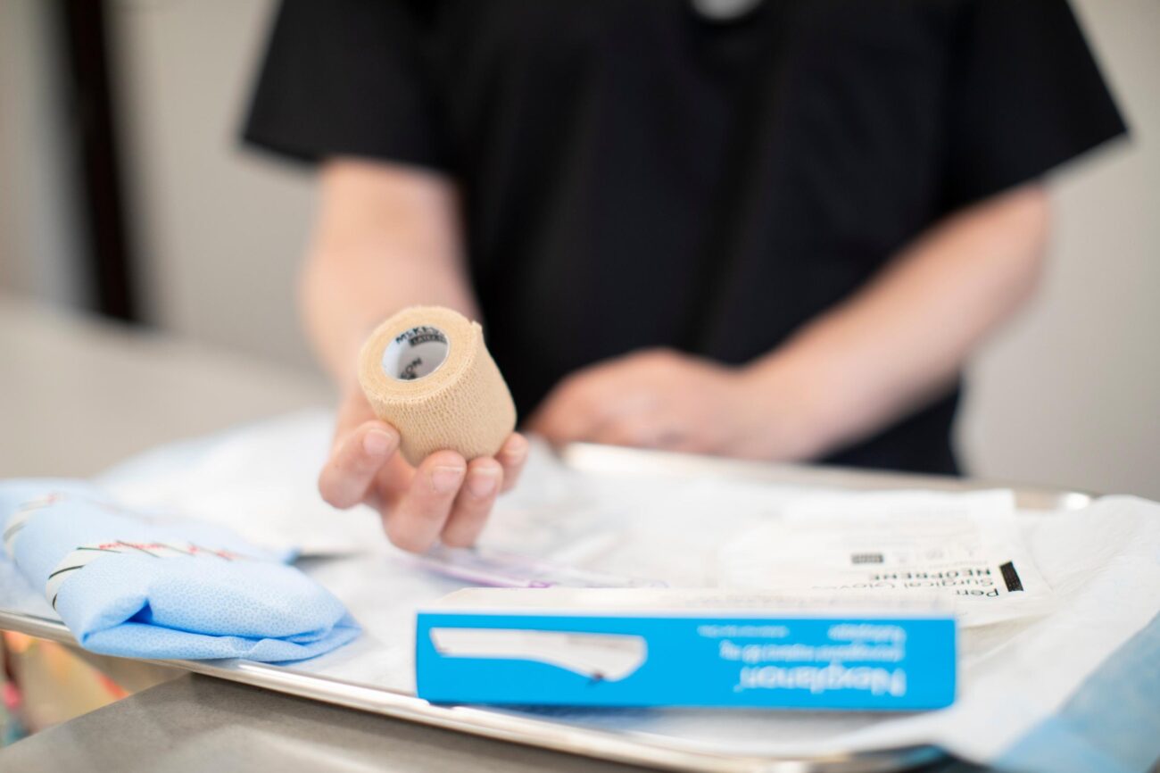 A healthcare professional holds medical wrap and other supplies prepared for podiatric care, highlighting readiness for foot and ankle treatments.